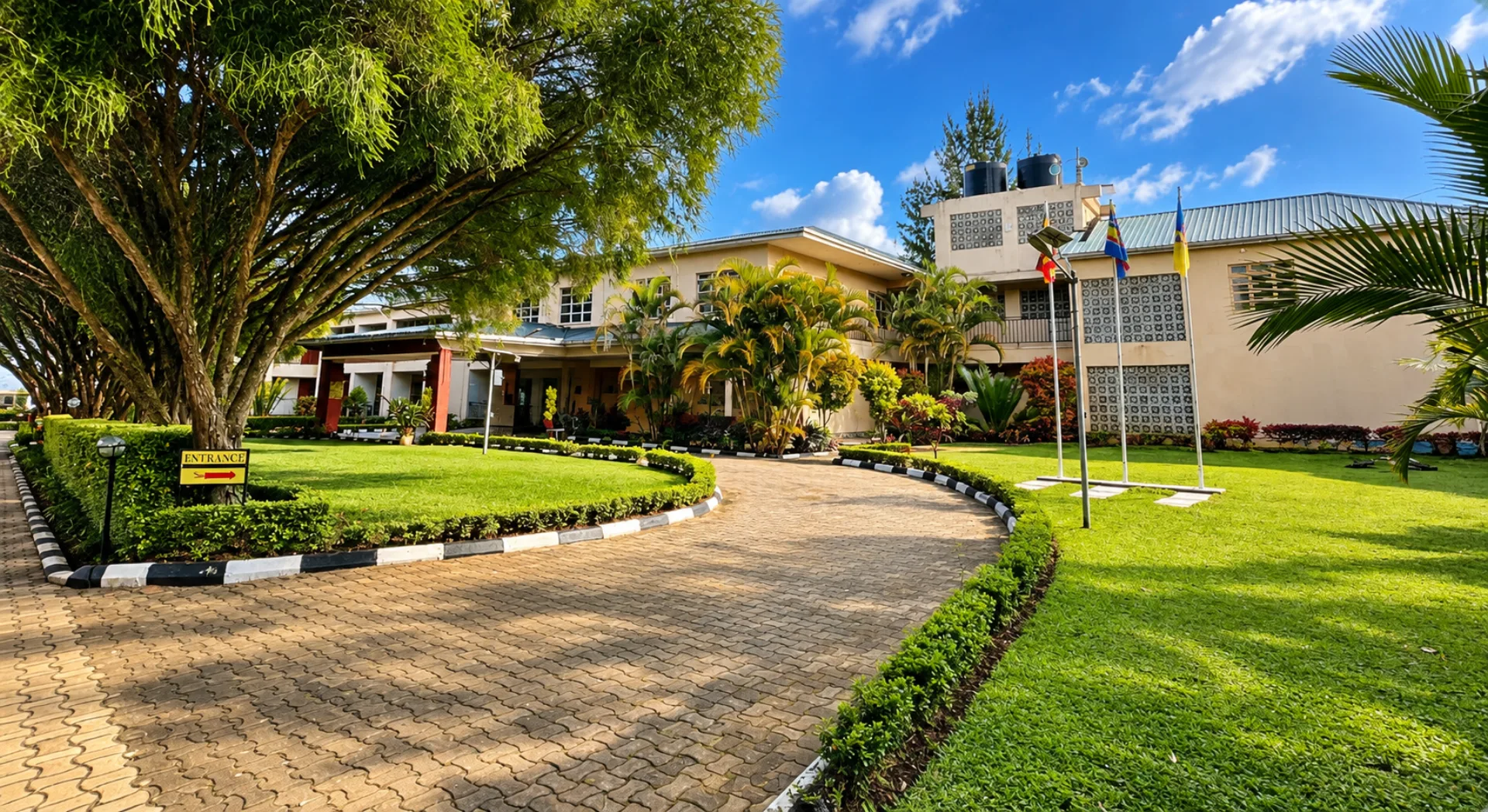 Tree-lined entrance and gardens at Kalya Courts Hotel